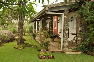 een stenen huis met een tuin ervoor bij Clouds Holiday Bungalow Haputhale in Haputale