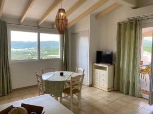un salon avec une table à manger et une télévision dans l'établissement Santa Giulia - Le village de L'hacienda, à Porto-Vecchio