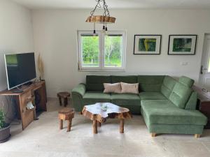 科雷尼察的住宿－Milka house，客厅配有绿色沙发和桌子