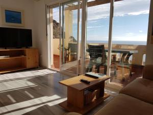 uma sala de estar com um sofá, uma televisão e uma mesa em Apartamento Vistas Espectaculares al Mar em Carboneras