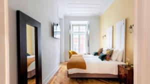 a bedroom with two beds and a mirror at LeL Madalena GuestHouse in Lisbon