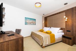 a bedroom with a bed and a desk and a television at Hotel Meduza in Senj