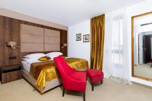 a hotel room with a bed and a red chair at Hotel Meduza in Senj