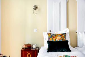 een slaapkamer met een bed met een kussen en een nachtkastje bij LeL Madalena GuestHouse in Lissabon