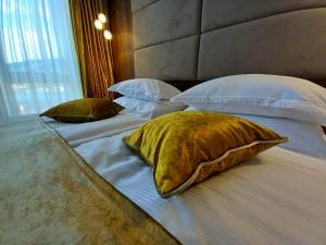 a large bed with three pillows on it at Hotel Meduza in Senj