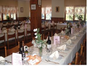 - une longue table avec des bouteilles de vin et du pain dans l'établissement Albergo Pineta, à Gerola Alta