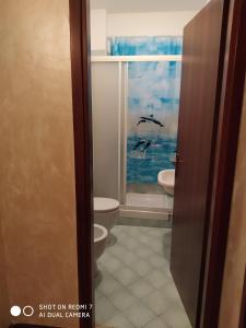 a bathroom with a toilet and a window with birds at Mamma Giulia in Stroncone