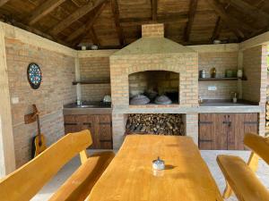 una mesa de madera en una cocina con horno de ladrillo en Milka house, en Korenica