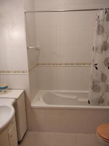 y baño con bañera y lavamanos. en calmo e simpatico apartamento, en Vila Praia de Âncora