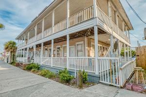 a large house with white trim on a street at Carbo House Eleven in Tybee Island