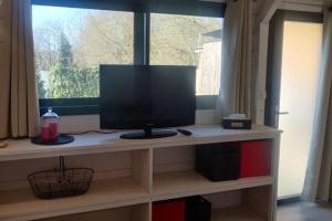 a computer monitor sitting on a shelf in front of a window at Gite La Basse-Cour in Cordemais