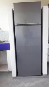 a white refrigerator sitting next to a table at Stromboliparadise Piscita in Stromboli