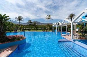 basen w ośrodku z palmami w obiekcie Benalbeach w mieście Benalmádena