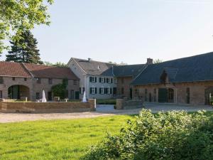 a group of buildings with a yard and grass at Gut Hohenholz in Bedburg