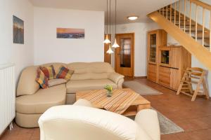 una sala de estar con un sofá y una mesa en Ferienpark Freesenbruch Reihenhaus 6b - Schwalbe, en Zingst