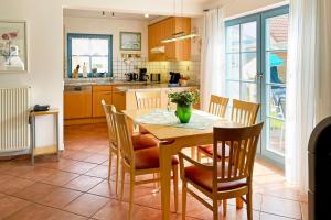 a kitchen and dining room with a table and chairs at Ferienpark Freesenbruch Doppelhaushälfte 11 - Windflüchter in Zingst