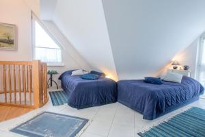 two beds with blue sheets in a room at Appartementhaus Boddenblick "Himmelkieker" in Zingst