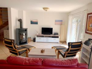 ein Wohnzimmer mit einem Sofa und einem Holzofen in der Unterkunft Haus Leni in Prerow