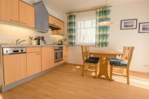 a kitchen with a wooden table and a dining room at Hoppenberg 7 EG links in Zingst