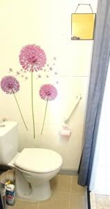 a bathroom with a toilet with purple flowers on the wall at Loft LE ROOF in Bahus-Soubiran +5 photos