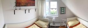 a small room with a bed and a window at Haus Zeesenboot Luv in Hiddensee