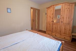 a bedroom with a large bed and a wooden cabinet at Hoppenberg 9 EG links in Zingst