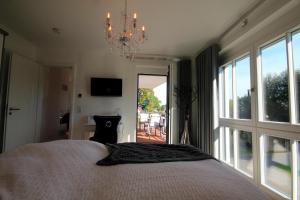 a bedroom with a large bed and a chandelier at Logierhaus Friedrich WE 11 - "Strandmuschel" in Zingst