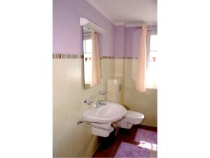 ein Badezimmer mit einem Waschbecken, einem WC und einem Spiegel in der Unterkunft Mühlenstrasse 19 - Wohnung 3 in Zingst