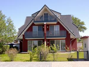 ein rotes Haus mit Fenstern und einem Dach in der Unterkunft Mühlenstrasse 19 - Wohnung 3 in Zingst