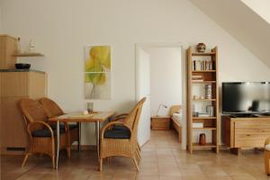 a living room with a table and chairs and a television at Residenz am Strand Wohnung 2-40 in Zingst