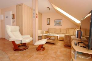 ein Wohnzimmer mit weißen Stühlen und einem Sofa in der Unterkunft Residenz am Strand Wohnung 3-54 in Zingst