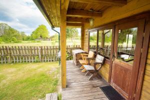 a porch of a wooden house with benches on it at Pas Kaziuką namukas in Palūšė