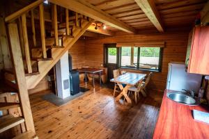 a kitchen and dining room of a log cabin at Pas Kaziuką namukas in Palūšė