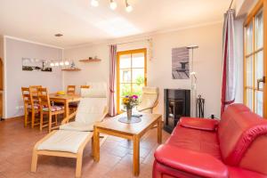 a living room with a red couch and a table at Ferienpark Freesenbruch Reihenhaus 8 - Zum Meer in Zingst