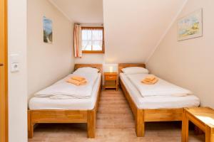 two twin beds in a small room with a window at Ferienpark Freesenbruch Reihenhaus 8 - Zum Meer in Zingst +32 photos