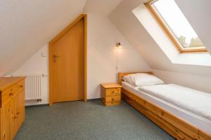 a attic bedroom with a bed and a window at Ferienpark Freesenbruch Wohnung 4 6 - Boddenblick in Zingst +31 photos