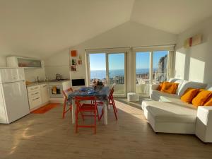 cocina y sala de estar con mesa y sofá en Casa Kalika, en Cefalú