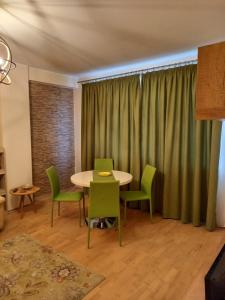 コンスタンツァにあるCasin Summer Apartmentのダイニングルーム(テーブル、緑の椅子付)