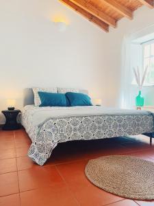 a bedroom with a large bed with blue pillows at Casa da Vila in Odeceixe