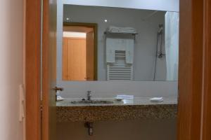 a bathroom with a sink and a large mirror at Mosteiro De S. Cristovao De Lafoes in São Cristóvão de Lafões