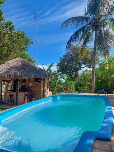 a large blue swimming pool next to a hut at Casa Suiça Brasileira in Jericoacoara