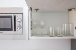a row of wine glasses sitting on a shelf next to a microwave at Zahobreña in Zahora