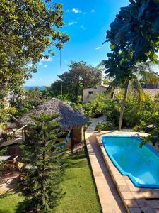 a garden with a swimming pool and a tree at Casa Suiça Brasileira in Jericoacoara