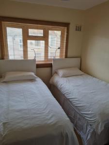 two beds sitting next to each other in a bedroom at Celtic House in Merthyr Tydfil