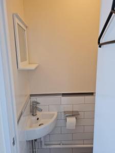 a white bathroom with a sink and a mirror at Celtic House in Merthyr Tydfil