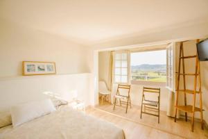 a bedroom with a bed and a table and chairs at CASA LAS OLAS DE LANGRE in Langre