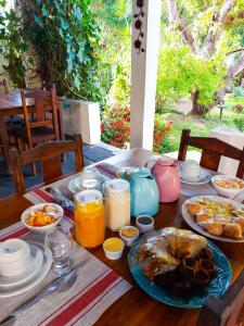 a wooden table with breakfast foods and drinks on it at Casa Suiça Brasileira in Jericoacoara
