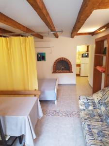 a living room with a yellow curtain and a couch at Apartman STELLA MARIS in Veli Lošinj