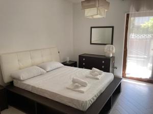 una camera da letto con un grande letto con asciugamani di Casa Ulivo a Pulsano