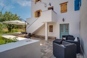 a white house with a staircase and chairs at Apartman STELLA MARIS in Veli Lošinj